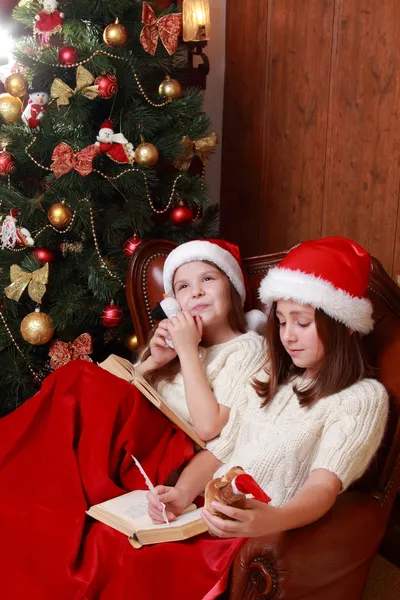 Meninas vestindo chapéus de Santa segurando livros — Fotografia de Stock