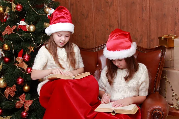 Chicas con sombreros de Santa sosteniendo libros — Foto de Stock