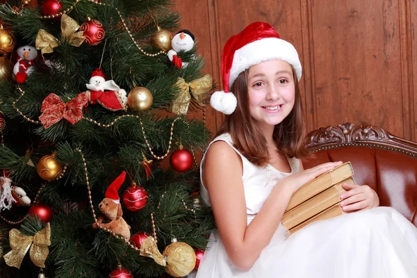 Liten flicka med böcker om jul — Stockfoto
