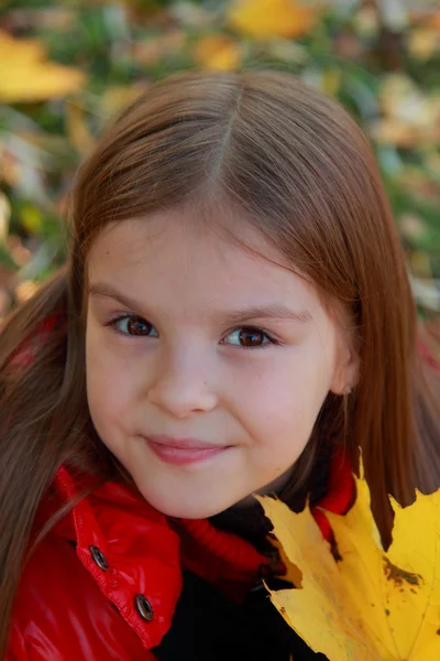 Petite fille jouant avec les feuilles tombées — Photo