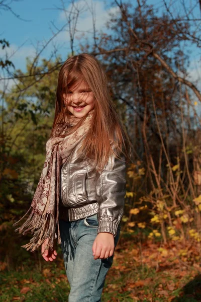 Liten flicka som leker i parken hösten — Stockfoto