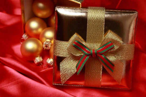 Geschenkbox mit goldenen Weihnachtskugeln — Stockfoto