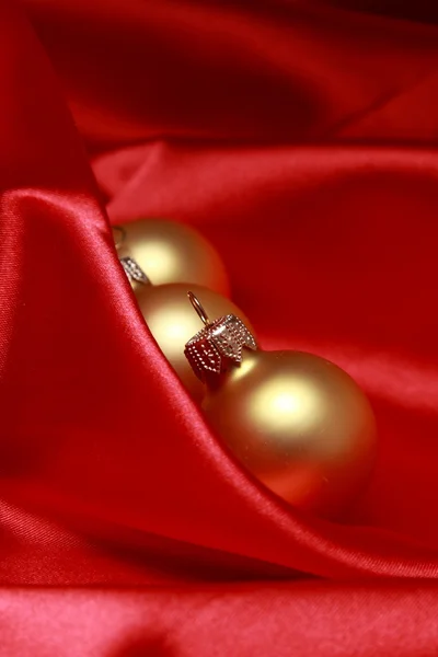 Zlaté koule na červeném pozadí — Stock fotografie