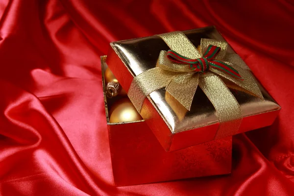 Geschenkbox mit goldenen Weihnachtskugeln — Stockfoto