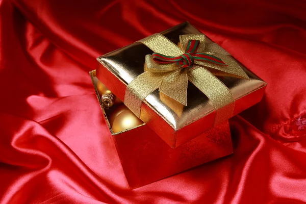 Geschenkbox mit goldenen Weihnachtskugeln — Stockfoto