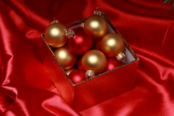 Geschenkdoos met gouden kerstballen — Stockfoto