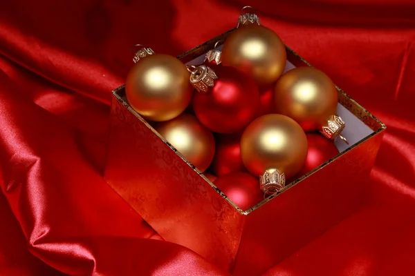 Geschenkbox mit goldenen Weihnachtskugeln — Stockfoto