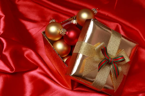 Geschenkbox mit goldenen Weihnachtskugeln — Stockfoto