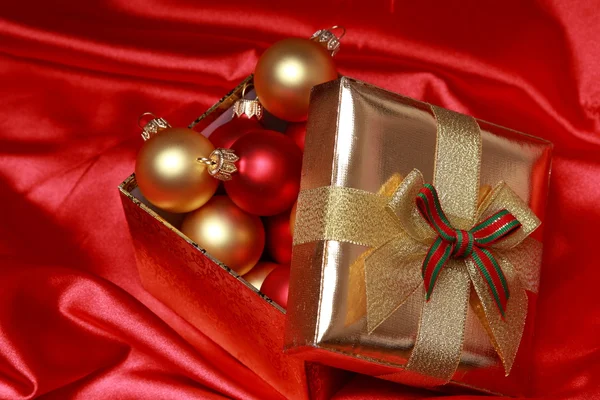 Geschenkbox mit goldenen Weihnachtskugeln — Stockfoto