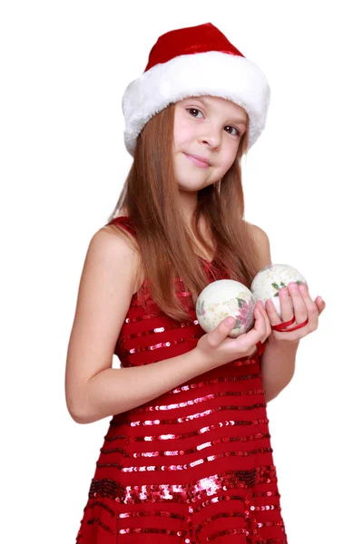 Kleines Mädchen mit Weihnachtsmütze zum Thema Urlaub — Stockfoto