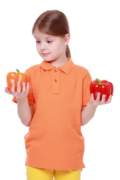 Little girl holding sweet peppers — Stock Photo, Image