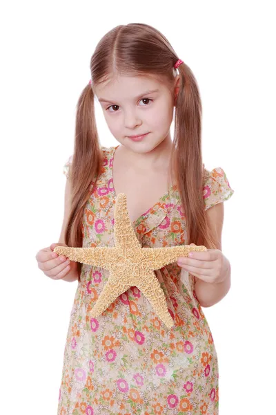 Little girl holds a large sea star — Stock Photo, Image