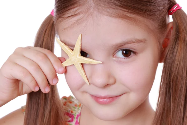 Little girl holds a sea star — Stock Photo, Image