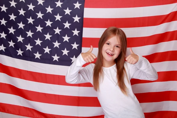 Little girl on the background of the American flag — Stock Photo, Image