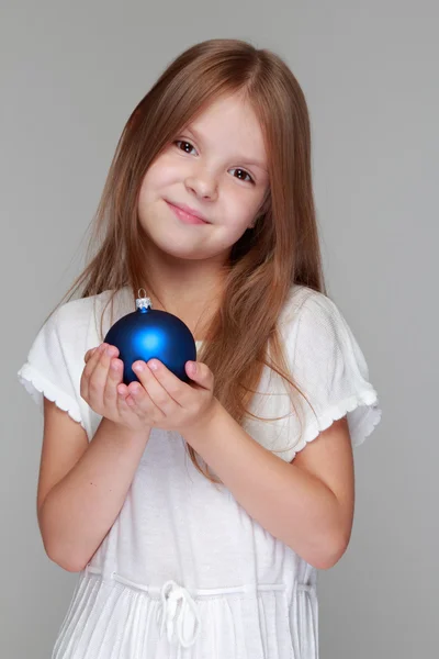 Девочка играет с рождественским мячом — стоковое фото