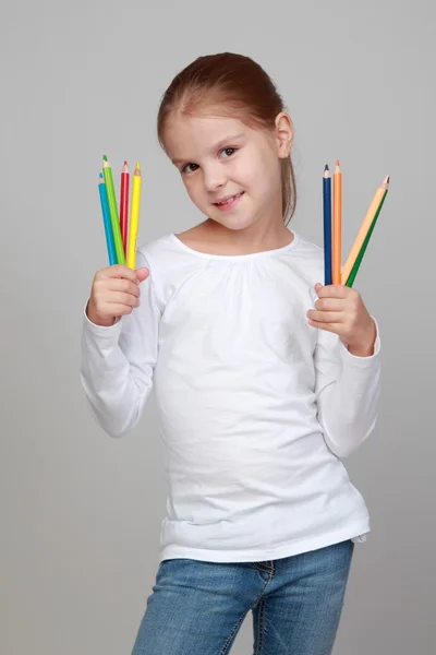 Child holds a lot of color pencils — Stock Photo, Image