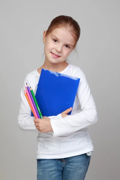 Menina segurando pastas e lápis — Fotografia de Stock