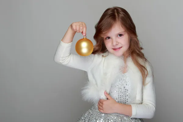 Chica sosteniendo una bola amarilla de Navidad — Foto de Stock