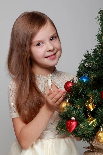 Kind siert een kerstboom — Stockfoto