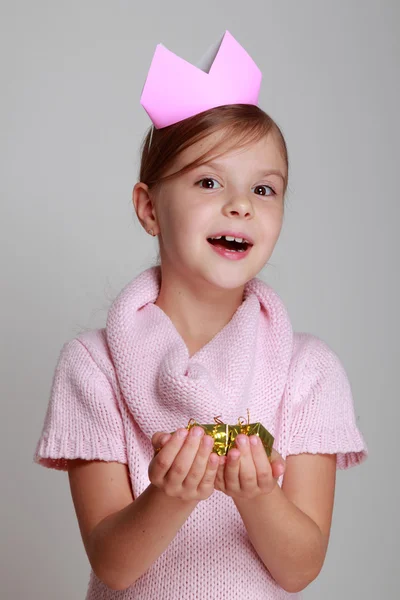 Mädchen mit Krone, die ein Geschenk hält — Stockfoto