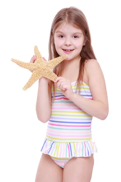 Menina com uma estrela do mar nas mãos — Fotografia de Stock