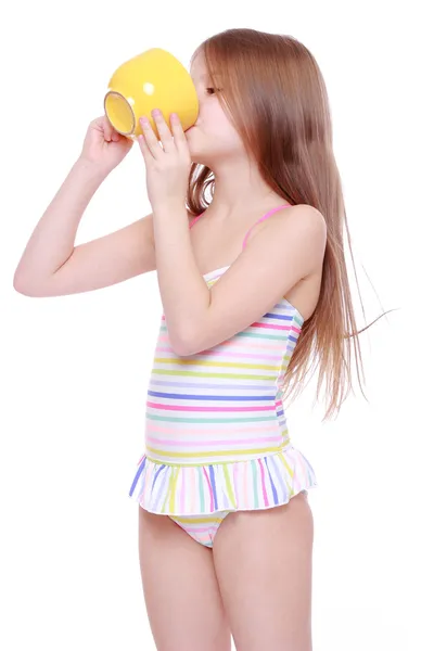 Kleines Mädchen mit großer gelber Tasse — Stockfoto