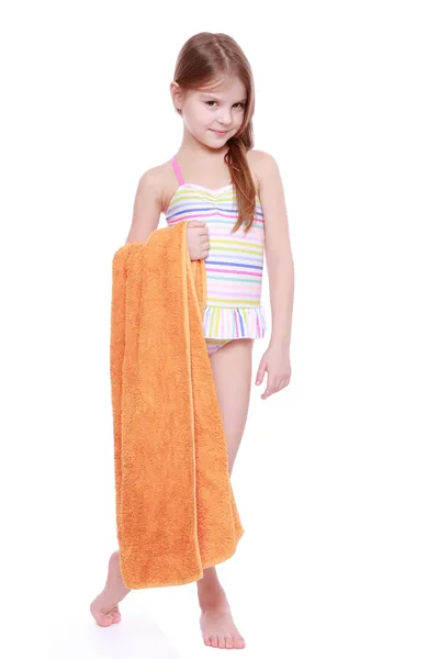 Little girl in swimsuit holding towel — Stock Photo, Image