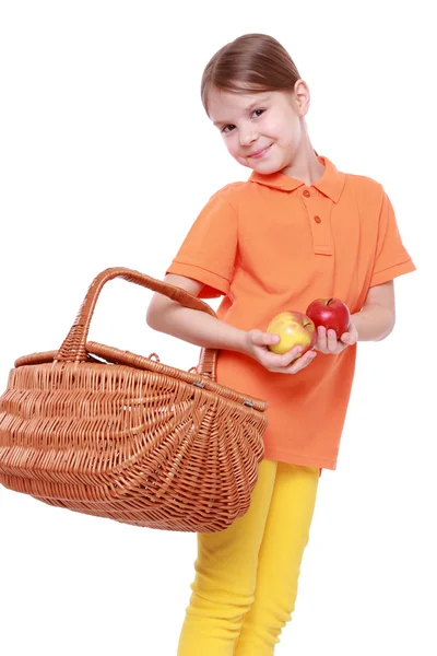 Dívka s jablky a košík — Stock fotografie