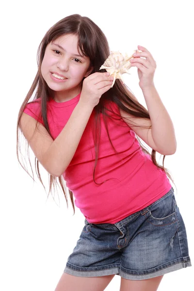 Flicka anläggning seashell — Stockfoto