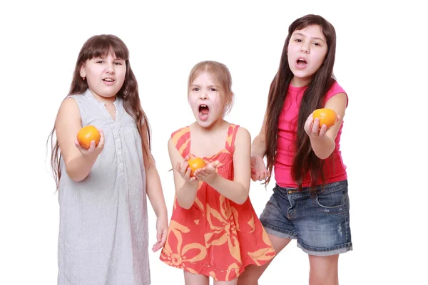 Little girls holding mandarins — Stock Photo, Image