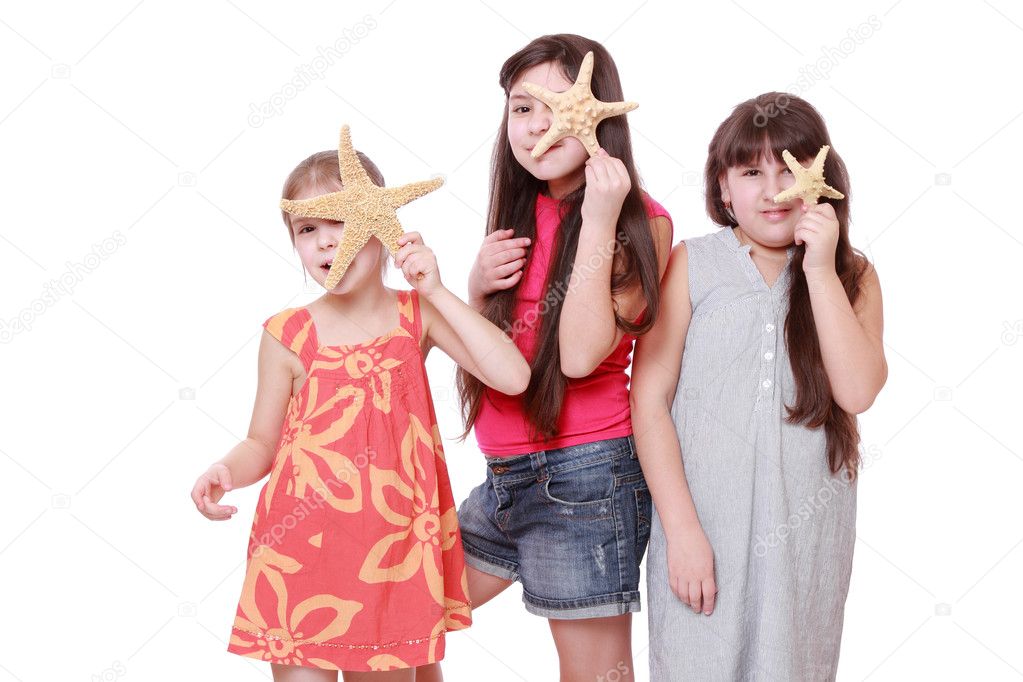 Cheerful positive little girls holding starfishes