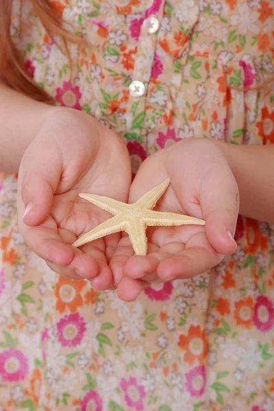 Mädchen hält Seesterne in der Hand — Stockfoto