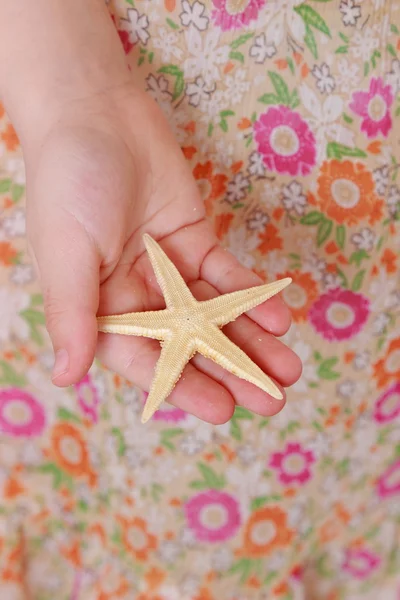 Girl holding starfish — Stock Photo, Image