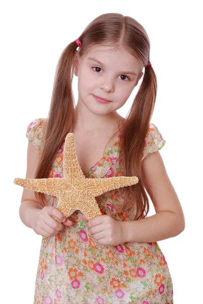 Chica sosteniendo una estrella de mar —  Fotos de Stock