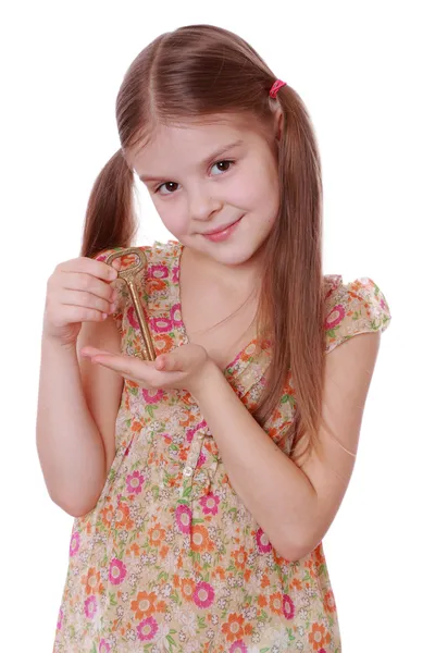 Menina segurando chave velha vintage dourada — Fotografia de Stock