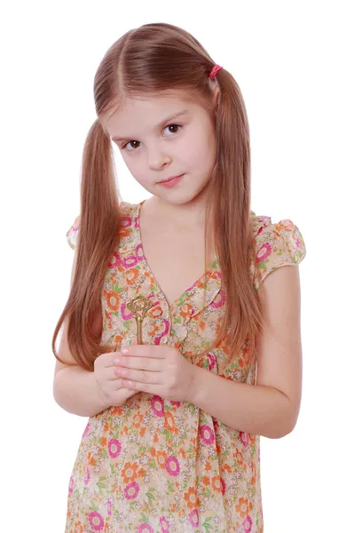 Menina segurando chave velha vintage dourada — Fotografia de Stock