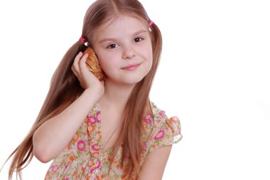 Deniz kabuğu tutan küçük bir kız