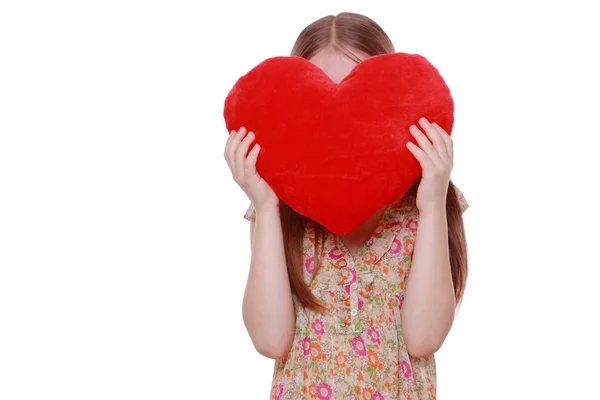 Menina abraçando um grande coração vermelho — Fotografia de Stock