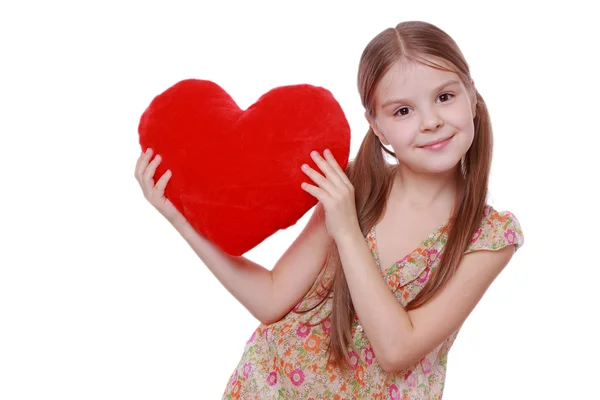 Chica abrazando un gran corazón rojo — Foto de Stock