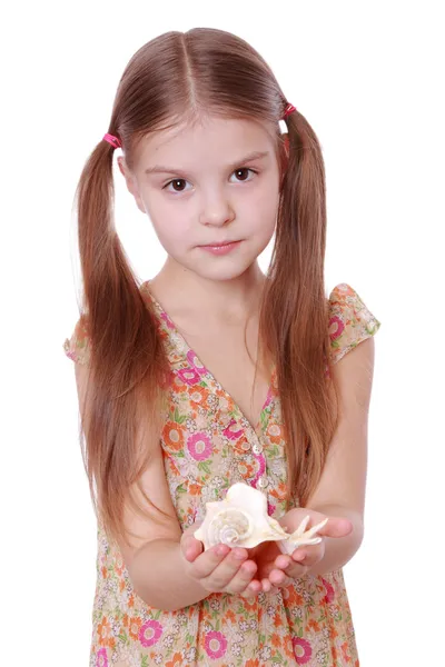 Маленькая девочка держит морскую раковину в руках — стоковое фото