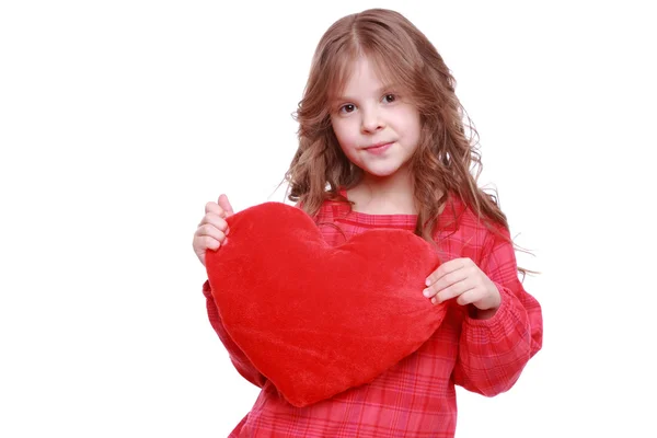 Chica abrazando un gran corazón de juguete —  Fotos de Stock