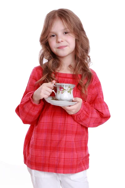 Маленькая девочка с чашкой чая и соусом — стоковое фото