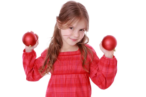 Niña sosteniendo bolas decorativas rojas — Foto de Stock