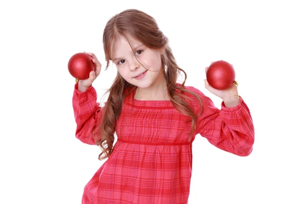 Klein meisje houdt van rode decoratieve ballen — Stockfoto