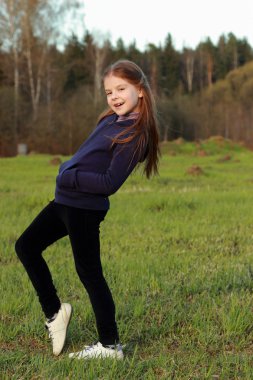 mały dziewczyna pozuje na zielonej trawie