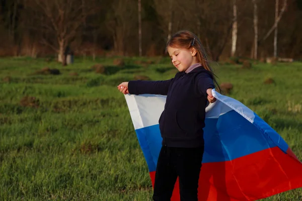 Девушка с большим российским флагом — стоковое фото