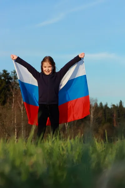 Fille tenant un grand drapeau russe — Photo