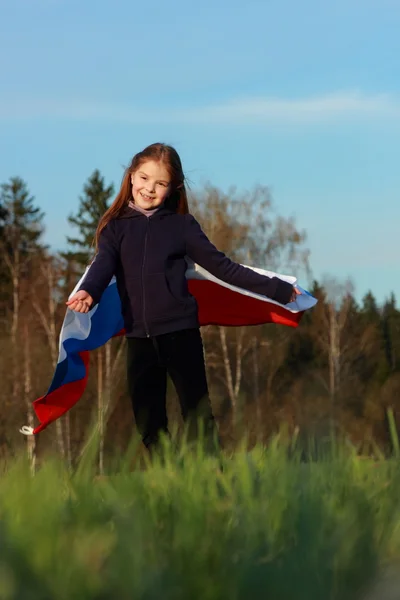 女孩抱着一个大型的俄罗斯国旗 — 图库照片