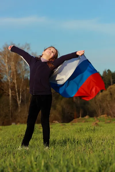 女孩抱着一个大型的俄罗斯国旗 — 图库照片