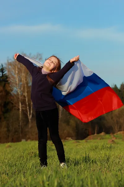 Девушка с большим российским флагом — стоковое фото